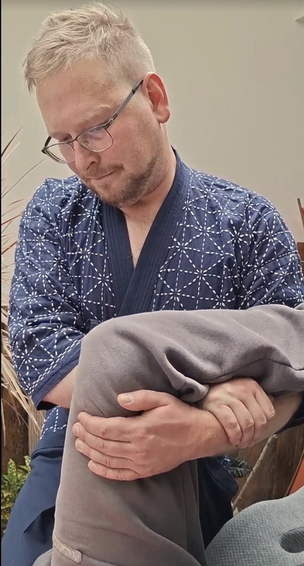 A hand resting on a shoulder during a session